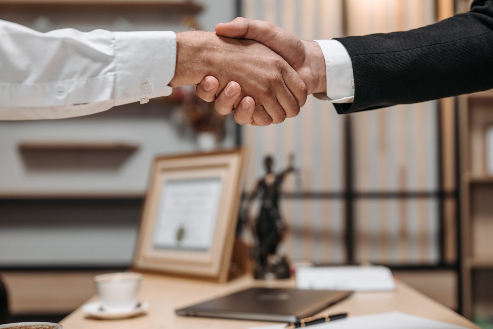 Two people shaking hands to close a deal